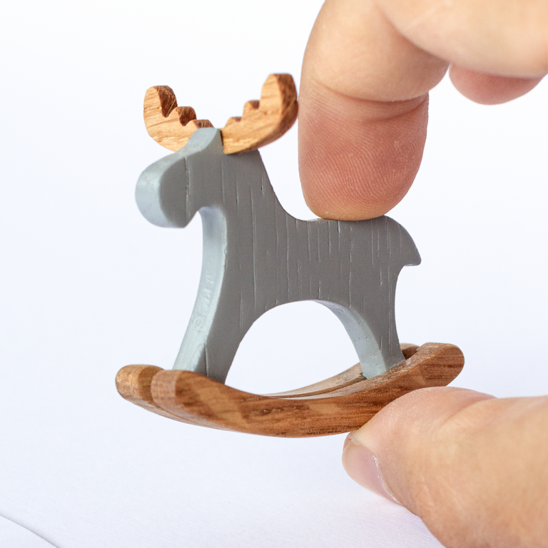 Miniature rocking elk held in fingers – actual size reference for 1:12 dollhouse
