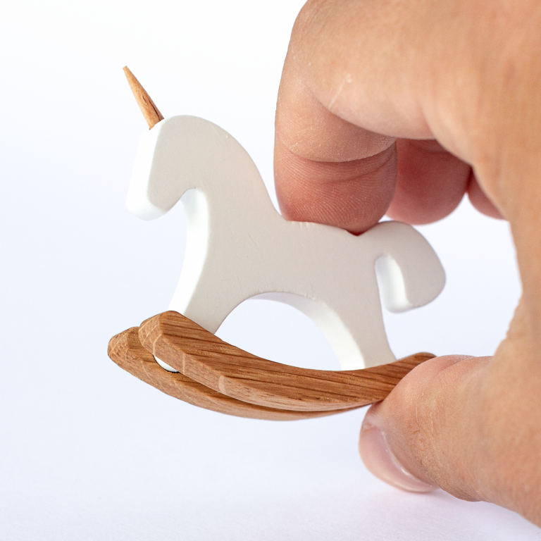 Miniature unicorn rocking horse held between fingers – actual size reference, 1:12 scale