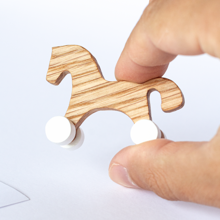 Miniature wooden wheeled horse held in fingers – actual size, 1:12 dollhouse scale