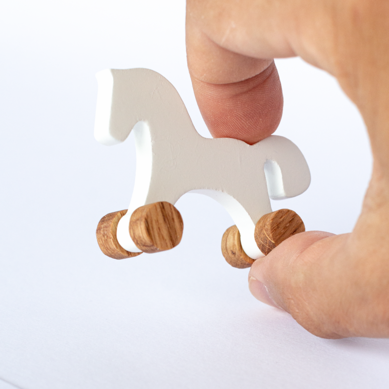 Miniature white wooden horse held in fingers – actual size reference, 1:12 dollhouse