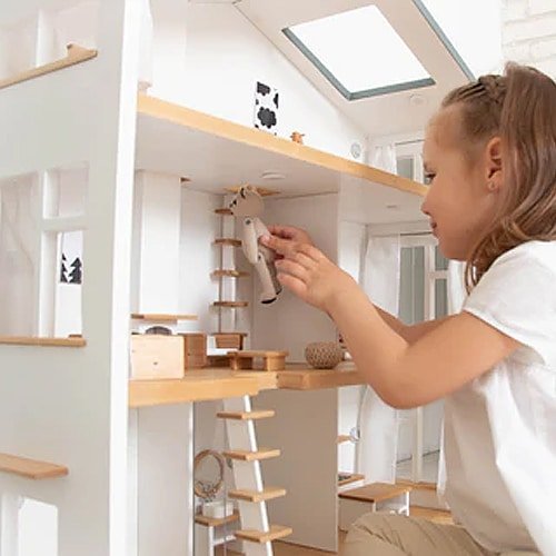 Girl playing with a bear doll in a big wooden dollhouse – showing the high ceiling rooms with plenty of space