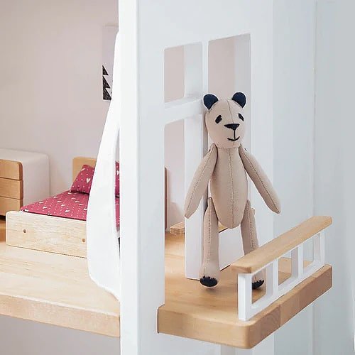 Bear doll standing on the balcony of a Katin Domik three-storey wooden dollhouse – extra play space outside