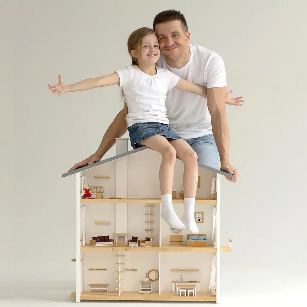 A proud father and his daughter at Katin Domik workshop, demonstrating the durability and safety of a handmade wooden dollhouse